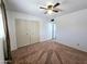 Bright bedroom featuring carpet flooring, a ceiling fan, and closet with paneled doors at 6815 W Reade Ave, Glendale, AZ 85303