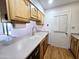 Bright kitchen featuring wood cabinets, laminate countertops, stainless steel sink, and white appliances at 6815 W Reade Ave, Glendale, AZ 85303