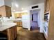 Traditional kitchen with wood cabinets, laminate countertops, and view into living room at 6815 W Reade Ave, Glendale, AZ 85303