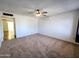 Bright living room featuring neutral carpet, ceiling fan, and wall-mounted air conditioning unit at 6815 W Reade Ave, Glendale, AZ 85303