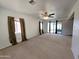 Large living room with neutral carpet, bright windows, and a ceiling fan at 6815 W Reade Ave, Glendale, AZ 85303