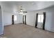 Spacious living room featuring neutral carpet, white walls, and well-lit windows at 6815 W Reade Ave, Glendale, AZ 85303