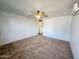 Open living room featuring neutral carpet, ceiling fan, and wall-mounted air conditioning unit at 6815 W Reade Ave, Glendale, AZ 85303