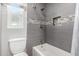 Updated bathroom with gray tile, bathtub shower combo, and modern vanity at 7004 N 11Th Way, Phoenix, AZ 85020