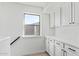 Laundry room with white cabinets and stacked washer and dryer at 7235 E Norwood St, Mesa, AZ 85207