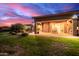 Inviting backyard featuring a covered patio, lush lawn, and a beautiful sunset sky at 7456 S Brighton --, Queen Creek, AZ 85142