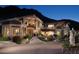 Luxury home with stone exterior, large windows, and dramatic mountain views at 8060 N Mummy Mountain Rd, Paradise Valley, AZ 85253