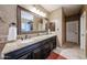 Elegant bathroom features a double vanity with granite countertop and large framed mirror at 9015 E Hackamore Dr, Scottsdale, AZ 85255