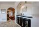 Hallway featuring a built-in bar area with sleek countertops and a mini-fridge for entertaining at 9015 E Hackamore Dr, Scottsdale, AZ 85255