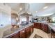 Open kitchen with a large island, granite counters, stainless hood, and dark wood cabinets at 9015 E Hackamore Dr, Scottsdale, AZ 85255