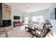 Comfortable living space with a white sofa, stacked stone fireplace, and rocking chair at 9015 E Hackamore Dr, Scottsdale, AZ 85255