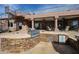 A custom outdoor kitchen features a stone surround, stainless steel grill, and a spiral staircase leading to the upper deck at 9015 E Hackamore Dr, Scottsdale, AZ 85255