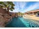 Backyard pool area with a rock waterfall feature and landscaping at 9015 E Hackamore Dr, Scottsdale, AZ 85255