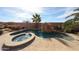 A luxurious backyard pool features a rock waterfall and attached spa, surrounded by a desert landscape and privacy wall at 9015 E Hackamore Dr, Scottsdale, AZ 85255