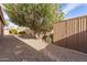 Backyard with storage shed, large tree, and gravel pathway at 9016 W Harmony Ln, Peoria, AZ 85382