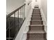 Interior staircase with patterned carpet runner and metal railing at 948 S Alma School Rd # 29, Mesa, AZ 85210