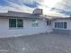 Rear view of the house showing its gray exterior and gravel area at 9902 W Coggins Dr, Sun City, AZ 85351