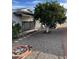 Landscaped front yard with gravel, trees, and stone accents at 9902 W Coggins Dr, Sun City, AZ 85351