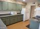 Kitchen with green cabinets, white appliances, and ample counter space at 9902 W Coggins Dr, Sun City, AZ 85351