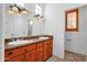 Bathroom featuring double sink vanity and a window for natural lighting at 9980 E Charter Oak Rd, Scottsdale, AZ 85260