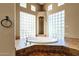 Large soaking tub surrounded by tile work and glass block windows at 9980 E Charter Oak Rd, Scottsdale, AZ 85260