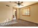 Bright bedroom with ceiling fan, carpet flooring, a window, and access to the bathroom at 9980 E Charter Oak Rd, Scottsdale, AZ 85260