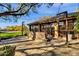 Exterior view of the home's outdoor bar area with tile roofing, brick accents, and string lights at 9980 E Charter Oak Rd, Scottsdale, AZ 85260