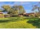 Beautifully manicured front yard featuring mature trees and lush green grass, enhancing the home's curb appeal at 9980 E Charter Oak Rd, Scottsdale, AZ 85260