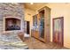 Kitchen with a wine fridge, stone fireplace, and custom cabinets at 9980 E Charter Oak Rd, Scottsdale, AZ 85260