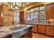 Kitchen features an island sink, wooden cabinets, and a large window at 9980 E Charter Oak Rd, Scottsdale, AZ 85260