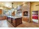 Gourmet kitchen with a large island, stone accents, and wooden cabinetry at 9980 E Charter Oak Rd, Scottsdale, AZ 85260