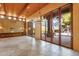 Living room features stone floors, wood-beamed ceilings, and large windows at 9980 E Charter Oak Rd, Scottsdale, AZ 85260