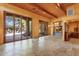 Bright living room with wood ceilings, stone floors, and glass doors to the outside at 9980 E Charter Oak Rd, Scottsdale, AZ 85260