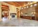 Living room with stone floors, wood ceilings, and a fireplace at 9980 E Charter Oak Rd, Scottsdale, AZ 85260