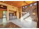 Spacious living room features a stone accent wall, bar area, and tiled flooring at 9980 E Charter Oak Rd, Scottsdale, AZ 85260