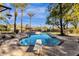 Swimming pool with a diving board, set amidst lush landscaping and tall palm trees in backyard at 9980 E Charter Oak Rd, Scottsdale, AZ 85260