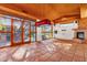 Open recreation room featuring a fireplace, tile floors, wood ceilings, and large windows at 9980 E Charter Oak Rd, Scottsdale, AZ 85260