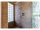 Walk-in shower featuring tile surround and a glass block window at 9980 E Charter Oak Rd, Scottsdale, AZ 85260