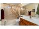Bathroom with tub, toilet and wood vanity at 13907 W Gable Hill Dr, Sun City West, AZ 85375