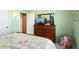 Bedroom with wood dresser and leafy patterned bedding at 13907 W Gable Hill Dr, Sun City West, AZ 85375