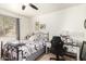 Bright bedroom featuring a patterned bedspread, side desk, and comfortable chair at 14765 W Alexandria Way, Surprise, AZ 85379