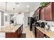Modern kitchen with granite countertops, black appliances, and ample storage at 14765 W Alexandria Way, Surprise, AZ 85379