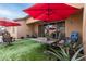 Relaxing covered patio with comfortable seating and a stylish red sun umbrella at 14765 W Alexandria Way, Surprise, AZ 85379