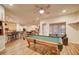 Well-lit game room with a pool table, bar seating, and hardwood floors at 1716 S 141St Pl, Gilbert, AZ 85295