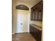 View of the butlers pantry with dark cabinets and decorative countertop between a doorway and closet doors at 1890 W Wisteria Dr, Chandler, AZ 85248