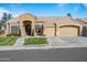 Tan two-story house with three-car garage and lush landscaping at 1890 W Wisteria Dr, Chandler, AZ 85248