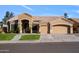 Inviting front of the house with a manicured lawn, arched entrance, and a spacious three-car garage at 1890 W Wisteria Dr, Chandler, AZ 85248