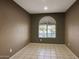 Bright bedroom with arched window and tile flooring at 19539 N 260Th Ln, Buckeye, AZ 85396