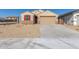 New home with a tan exterior, two-car garage, and a gravel driveway at 23256 W Miami St, Buckeye, AZ 85326