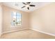 A tan bedroom features a window, ceiling fan and carpeted flooring at 263 W Rosemary Dr, Chandler, AZ 85248